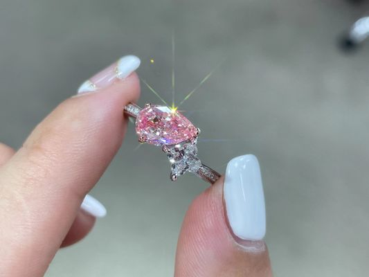 Une perle rose et blanche de 1,5 ct fabriquée en laboratoire par un adulte. Des diamants synthétiques avec une bague en or blanc de 18 carats.
